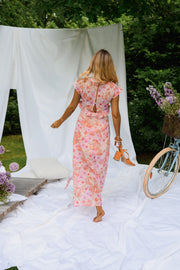 Robe fleurie longue à volants portée par une femme, en marchant, vélo, fente