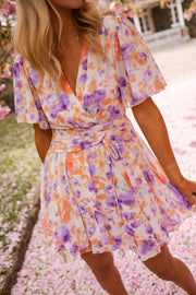Robe courte fleurie cache-cœur portée par une femme, vue rapprochée, cache-cœur, manches papillon