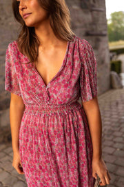 Robe plissée à col V portée par une femme, vue rapprochée, décolleté V, taille élastique
