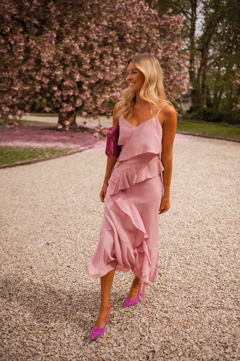 Robe longue à volants portée par une femme, silhouette entière, gravier, cerisiers