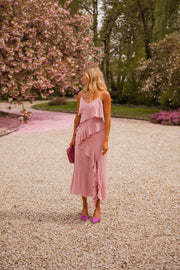 Robe longue à volants portée par une femme, silhouette entière, allée, cerisiers en fleurs