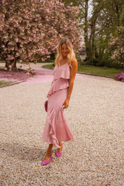 Robe longue à volants portée par une femme, vue de face, escarpins fuchsia, gravier