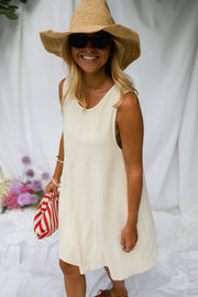 Robe éponge à dos ouvert portée par une femme, silhouette entière, chapeau de paille, lunettes