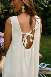 Robe éponge à dos ouvert portée par une femme, vue rapprochée, dos ouvert noué, boucles d'oreilles