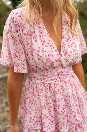 Robe à volants col V portée par une femme, vue rapprochée, décolleté V, imprimé fleuri