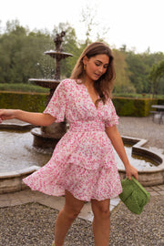 Robe à volants col V portée par une femme, en marchant, fontaine, sac vert