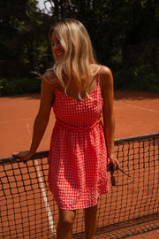 Robe vichy à bretelles portée par une femme, vue de trois-quarts, filet, main sur la hanche