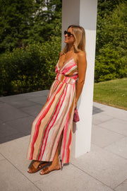 Robe rayée à décolleté V portée par une femme, vue de trois-quarts, poteau blanc, lunettes