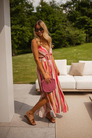 Robe rayée à décolleté V portée par une femme, en marchant, véranda, sac rose