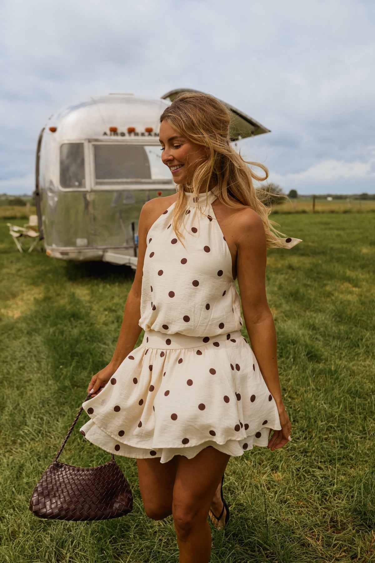 Robe à pois dos nu portée par une femme, silhouette entière, camping-car, herbe