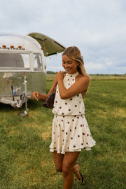 Robe à pois dos nu portée par une femme, vue de trois-quarts, camping-car, jupe volantée