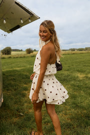 Robe à pois dos nu portée par une femme, vue de trois-quarts, herbe, camping-car