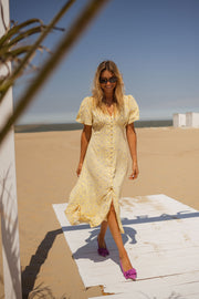 Robe satinée à boutons portée par une femme, silhouette entière, ponton, ciel bleu