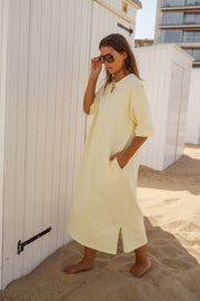 Robe ample à poches latérales portée par une femme, vue de face, sable, cabine