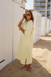 Robe ample à poches latérales portée par une femme, vue de face, lunettes, fente