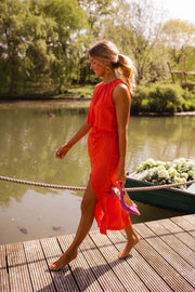 Robe fluide à col montant portée par une femme, en marchant, ponton, escarpins fuchsia