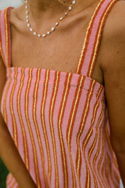 Robe éponge coupe droite portée par une femme, vue rapprochée, bretelles, rayures roses et orange