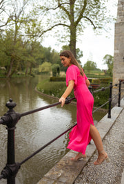 Robe fluide à fentes latérales portée par une femme, vue de face, rambarde, étang