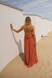 Robe fluide dos ouvert portée par une femme, vue de dos, cabine blanche, main sur le mur