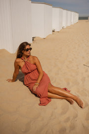 Robe fluide dos ouvert portée par une femme, assise, allongée, sable