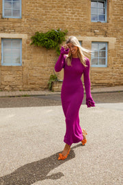 Robe moulante à manches évasées portée par une femme, vue de face, rue, volets bleus
