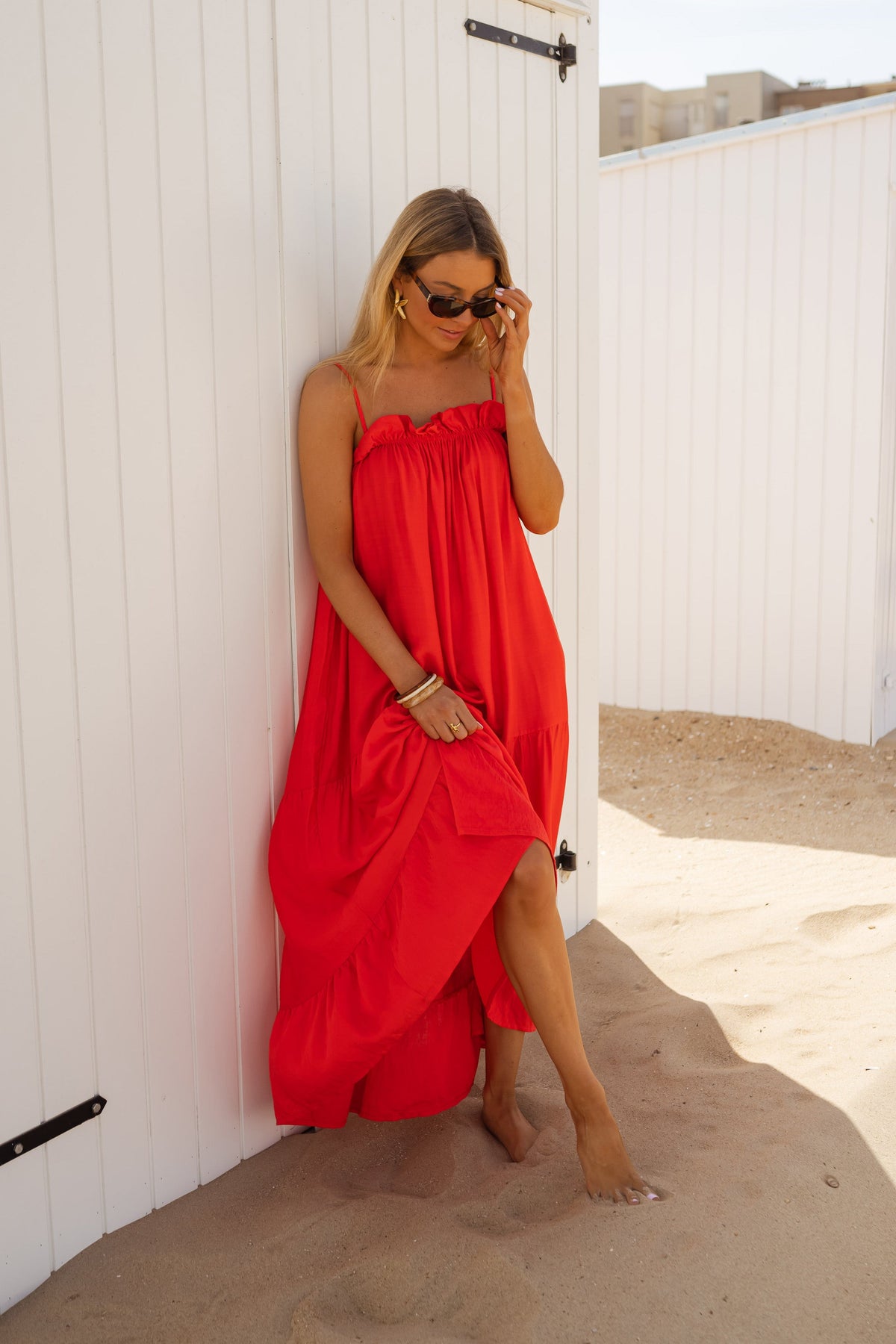 Robe fluide à col carré portée par une femme, silhouette entière, cabine blanche, sable