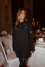 Robe pull brillante portée par une femme, vue de trois-quarts, chandeliers, table dressée