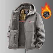 Veste grise à capuche, écussons visibles et graphisme de flamme.