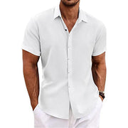 Chemise boutonnée manches courtes — blanche portée de face, mains dans les poches
