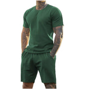 Ensemble de sport avec t-shirt — vert porté de face, mains dans les poches