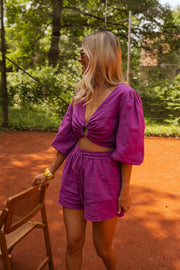 Short en lin à lien porté par une femme, vue de trois-quarts, chaises en bois, cheveux blonds