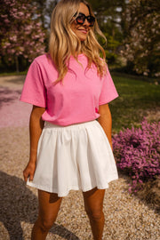 Short taille haute élastiqué blanc porté par une femme, vue de trois-quarts, lunettes, jupe-short