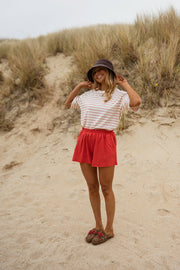 Short en coton effet délavé porté par une femme, silhouette entière, dunes, chapeau noir