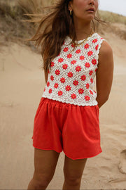 Short en coton effet délavé porté par une femme, vue de trois-quarts, haut à fleurs rouges, sable