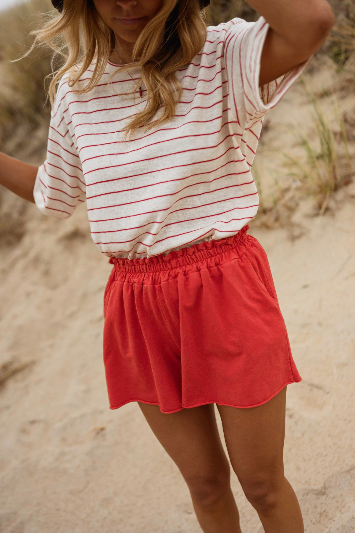 Short en coton effet délavé porté par une femme, vue rapprochée, t-shirt rayé, short rouge