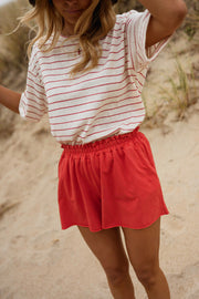 Short en coton effet délavé porté par une femme, vue rapprochée, t-shirt rayé, short rouge
