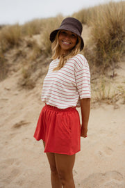 Short en coton effet délavé porté par une femme, vue de trois-quarts, dunes, chapeau