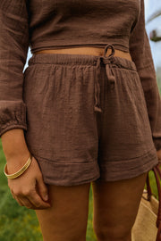 Short effet lin à nouer porté par une femme, vue rapprochée, short à nouer, bracelet