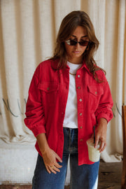 Surchemise en velours ample rouge portée par une femme, vue rapprochée, lunettes de soleil