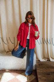 Surchemise en velours ample rouge portée par une femme, silhouette entière, sac à la main