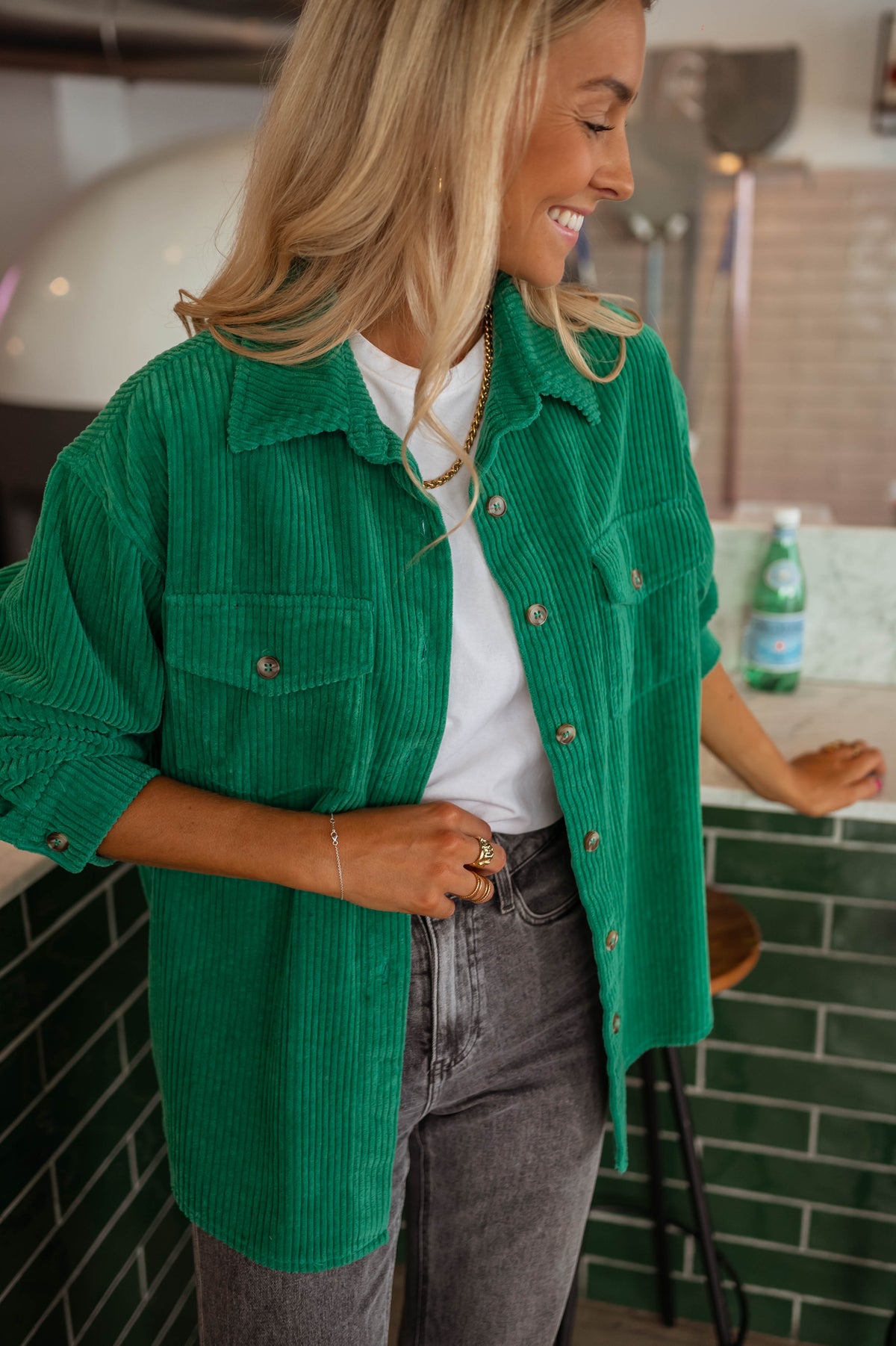 Surchemise fluide en velours verte portée par une femme, vue de face, bar vert, jean gris