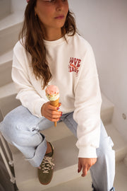 Sweat à col rond blanc porté par une femme, vue rapprochée, glace, jean clair