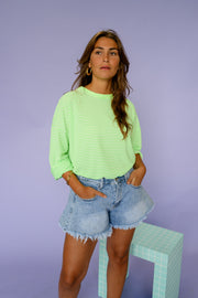 T-shirt rayé ample manches longues porté par une femme, silhouette entière, short en jean, vue de face