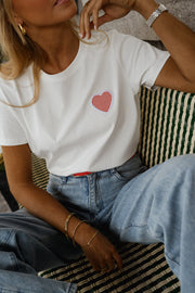 T-shirt blanc à cœur vichy rouge porté par une femme, vue rapprochée, cœur rose, ceinture rouge