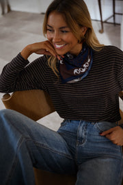 T-shirt rayé avec foulard porté par une femme, assise, fauteuil en bois, foulard bleu