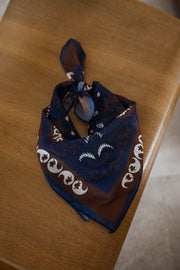 T-shirt rayé avec foulard porté par une femme, vue rapprochée, foulard bleu à motifs, table en bois