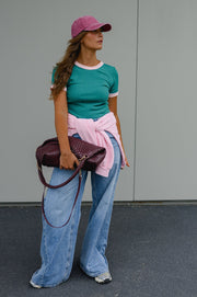 T-shirt moulant manches courtes porté par une femme, silhouette entière, casquette rose, pull rose noué à la taille