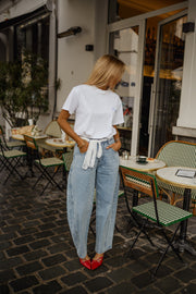 T-shirt à logo cœur dos porté par une femme, silhouette entière, baskets rouges, rue