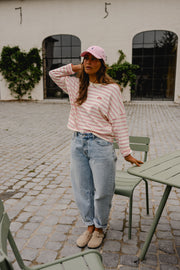 T-shirt rayé à manches longues rose porté par une femme, silhouette entière, casquette rose, jean