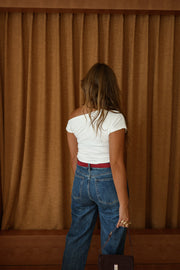 T-shirt moulant asymétrique écru porté par une femme, vue de dos, silhouette entière